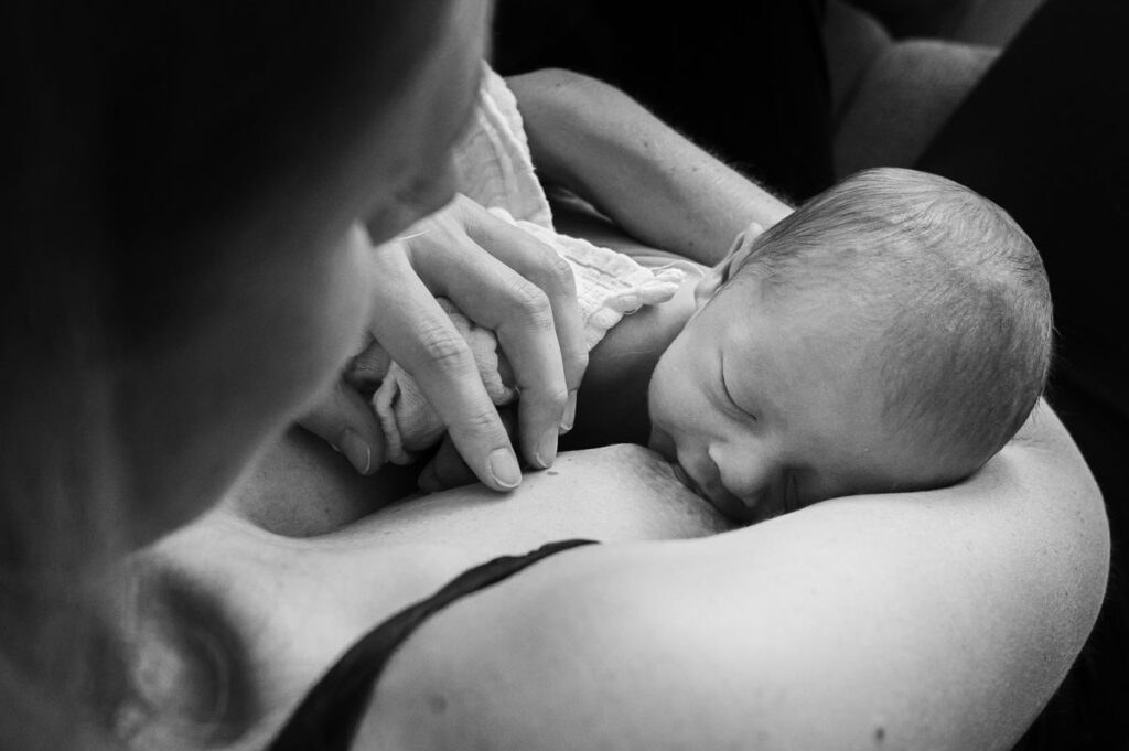 Zwei Wochen altes Baby wird gestillt.